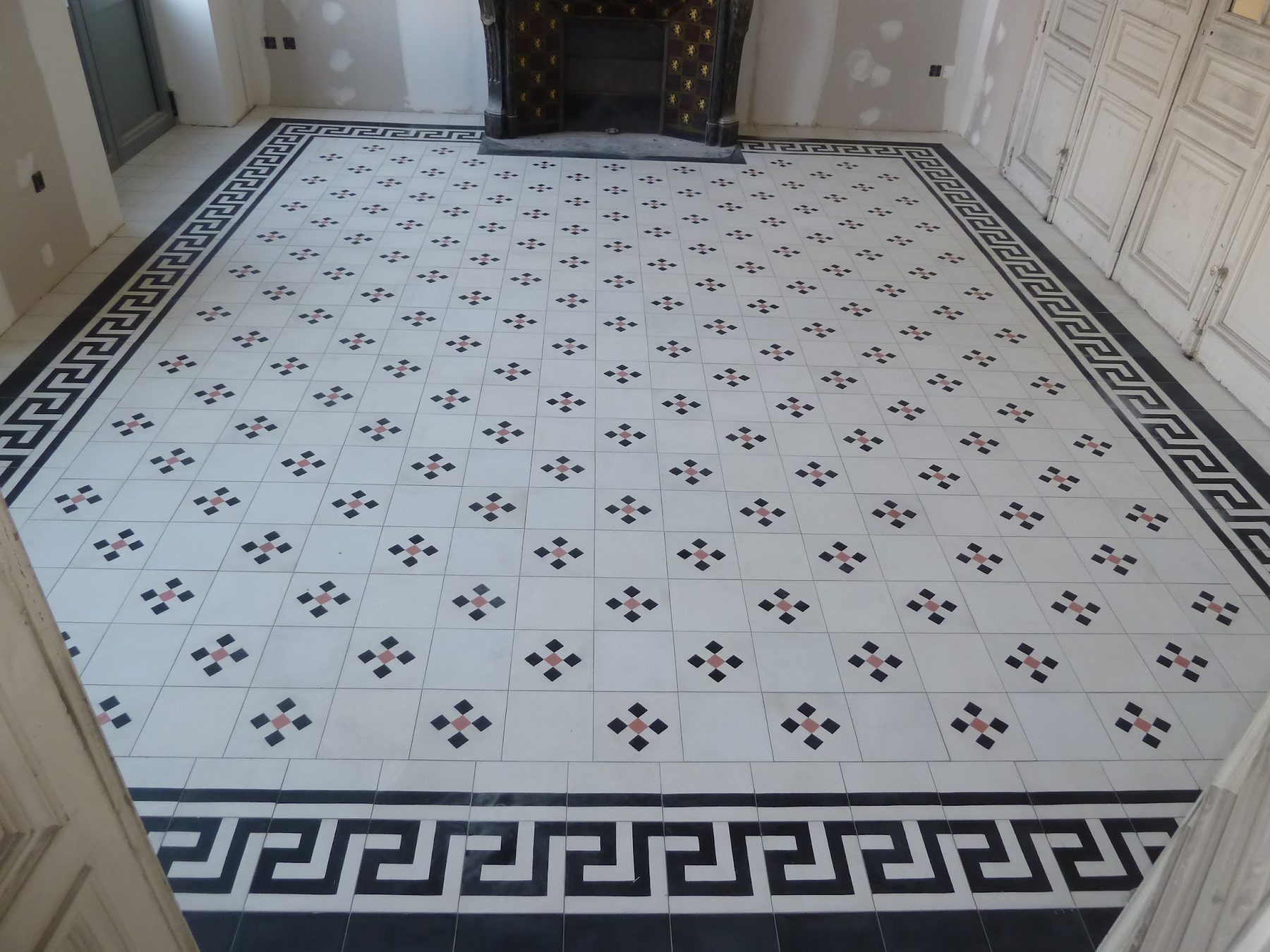 Entrée carrelée : carreaux à motifs et frise grecque noire et blanche