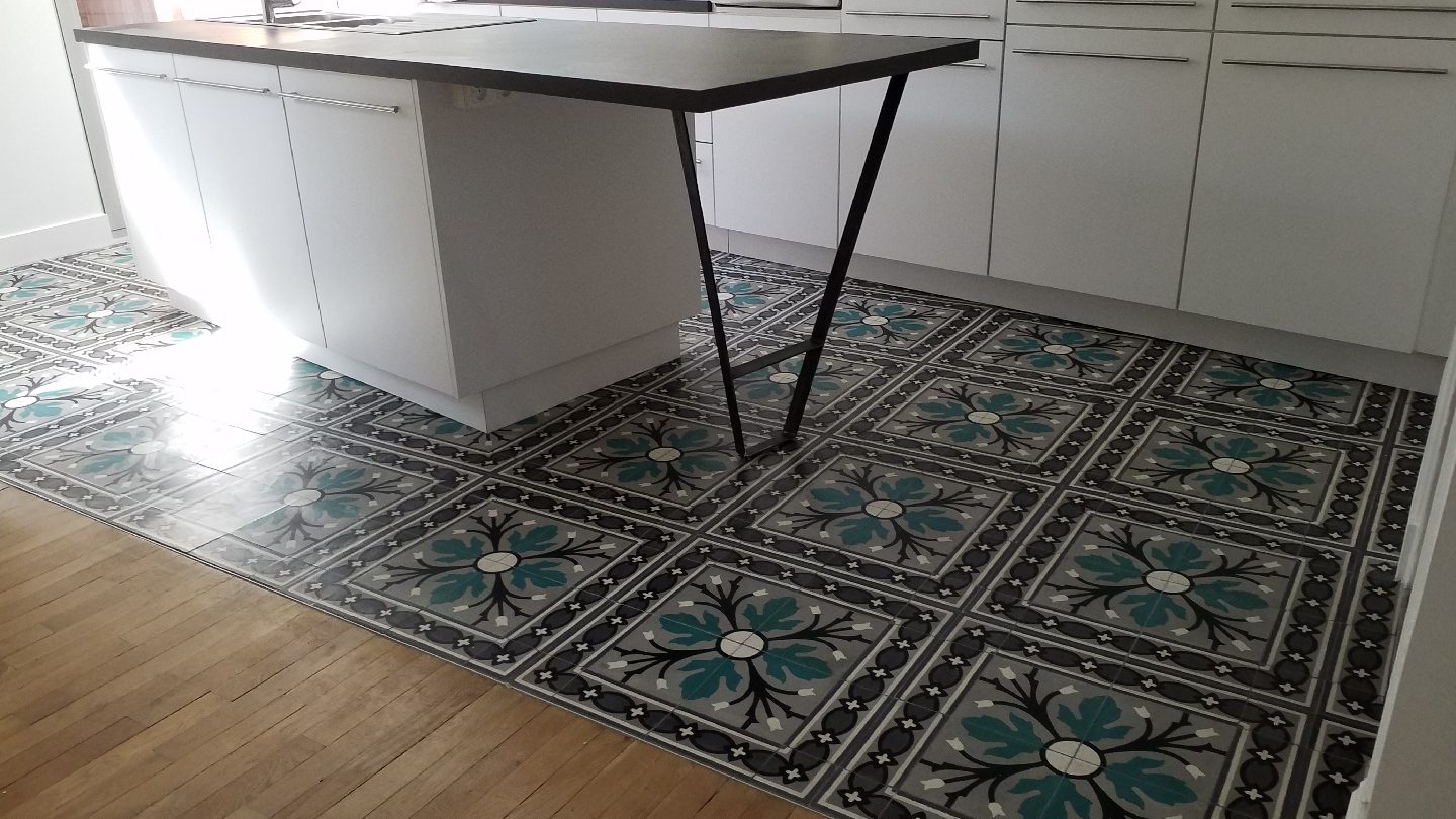 Tapis de carreaux de ciment sous l'îlot de cuisine, au milieu du parquet
